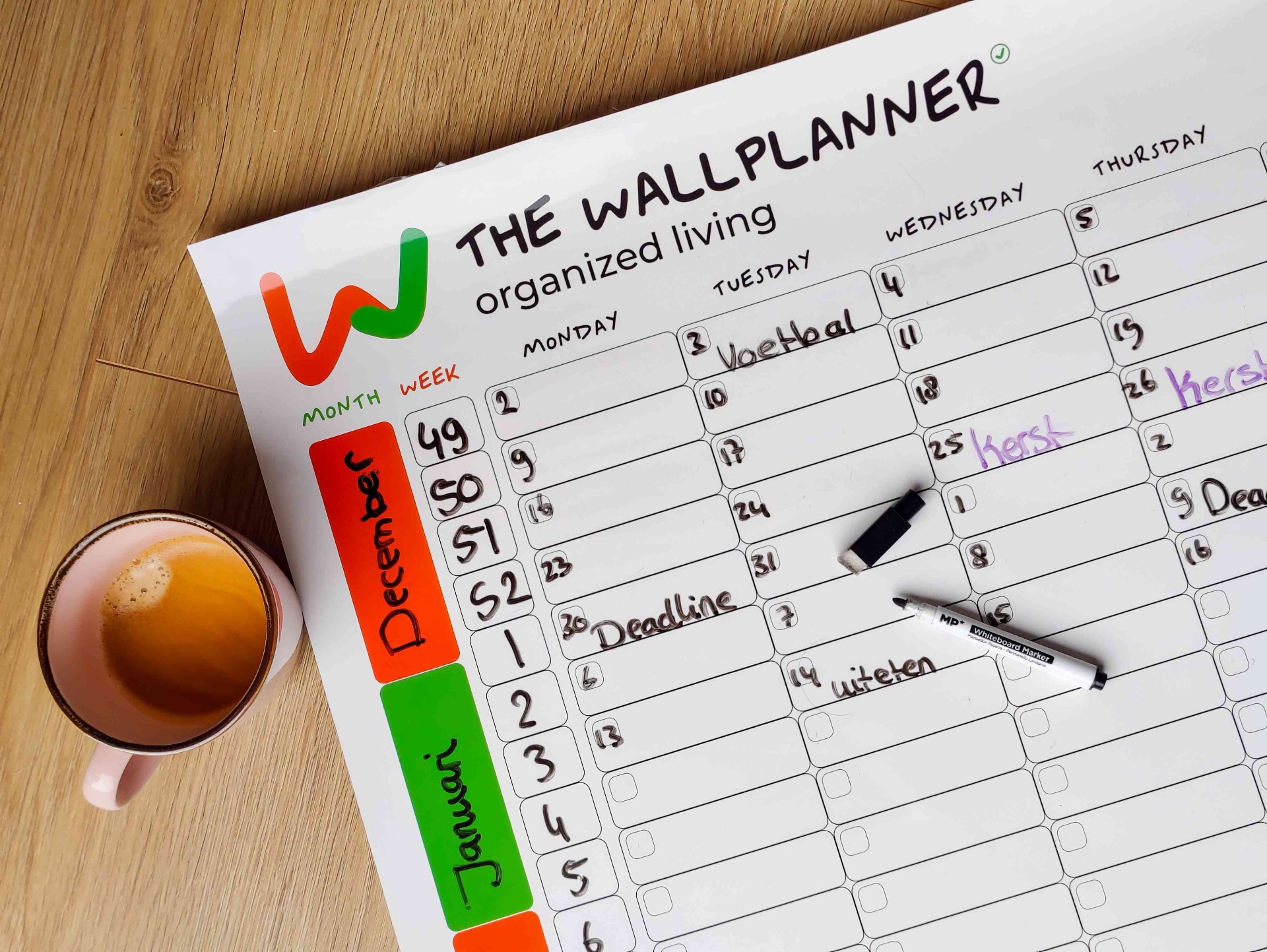 Weekplanner familie whiteboard aan keukenmuur met kleurgecodeerde gezinsafspraken voor het hele jaar